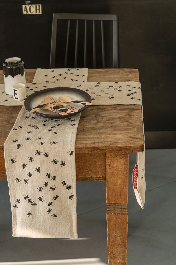 A weighted table runner printed with ants