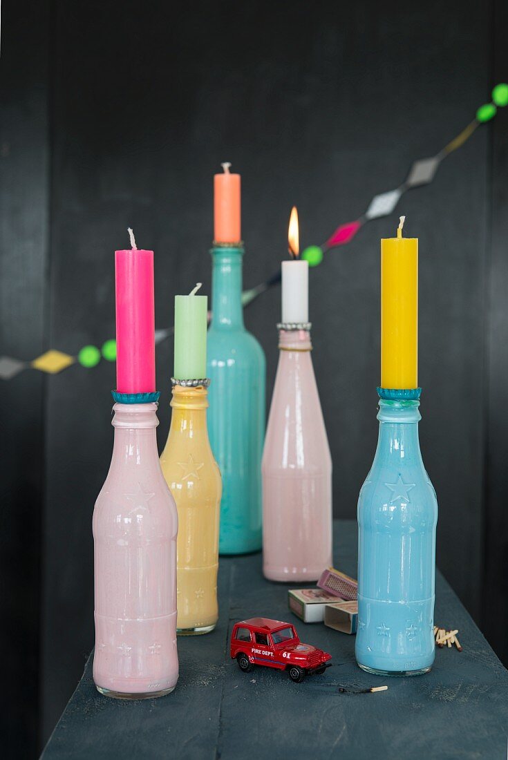 Colourful bottles being used as candleholders