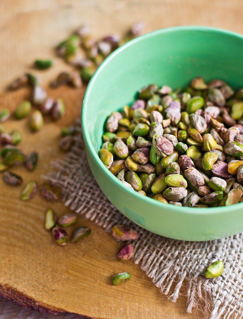 Shelled pistachios in a small bowl and next to it