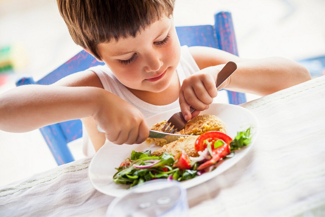 Kleiner Junge mit Kichererbsenburger