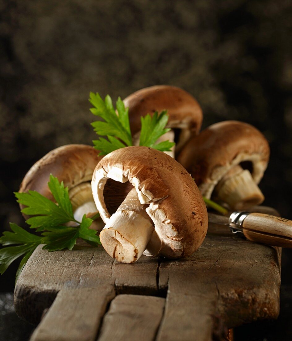 Brown mushrooms with flat-leaf parsley and a knife