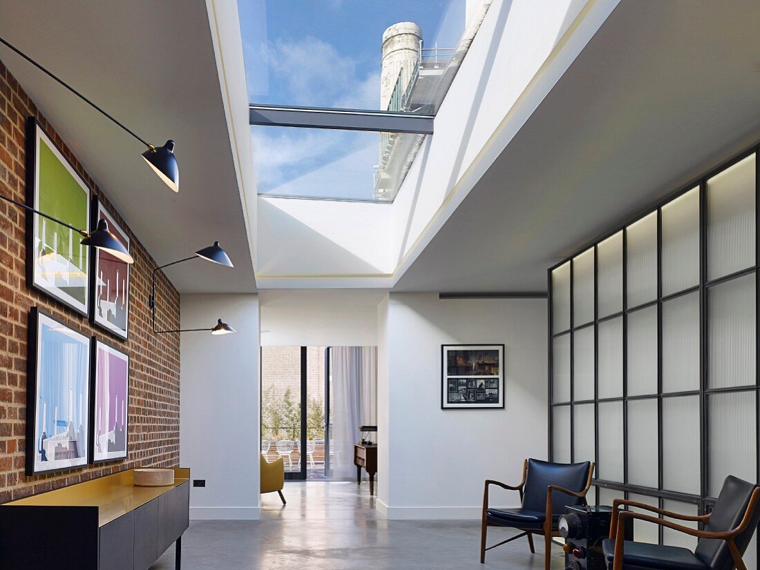 Skylight, brick wall and backlit wall elements in apartment foyer