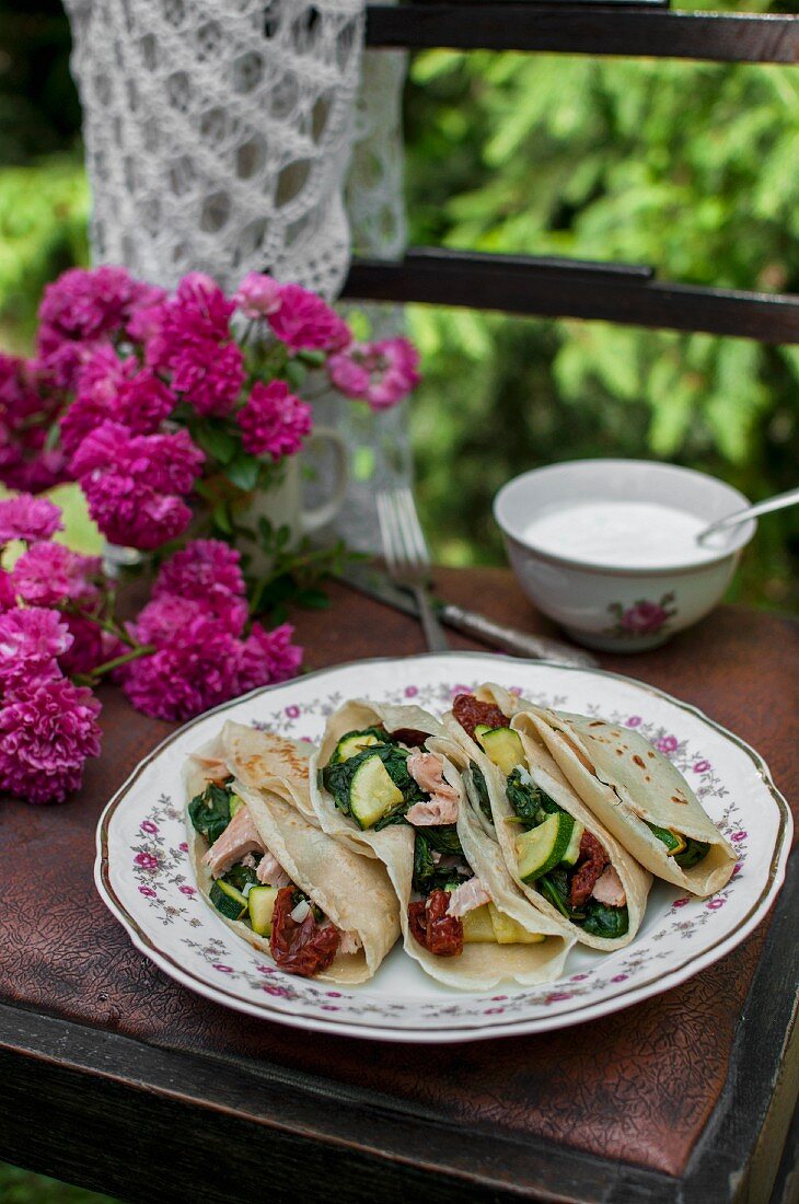 Crêpes with spinach, fried salmon, courgette and dried tomatoes served with a yoghurt sauce