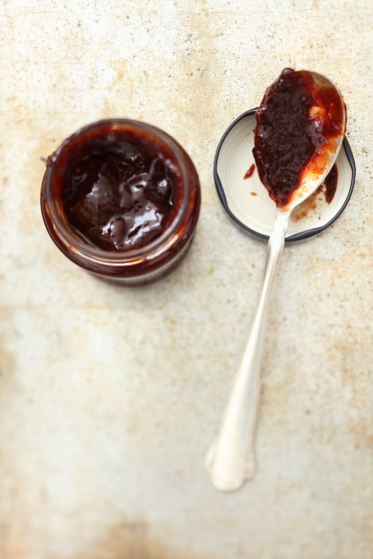 Plum jam in a jar and on a spoon