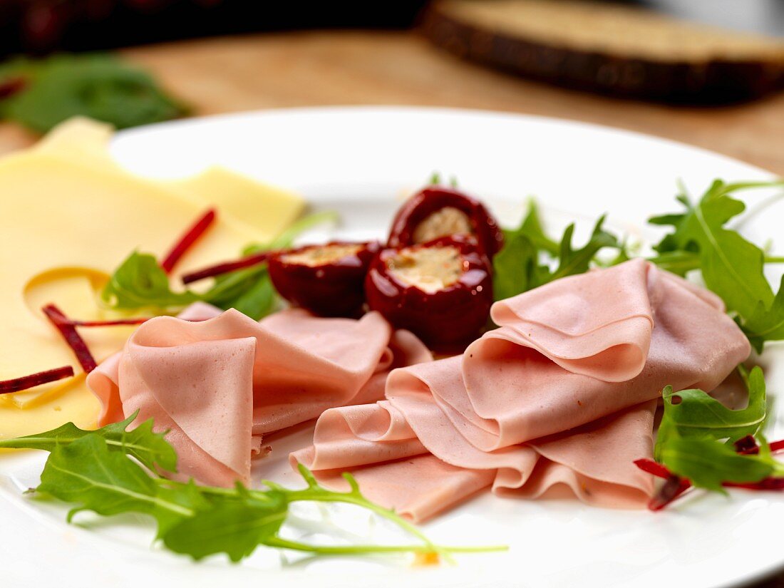 Ham sausage with stuffed peppers and Emmentaler cheese and rocket