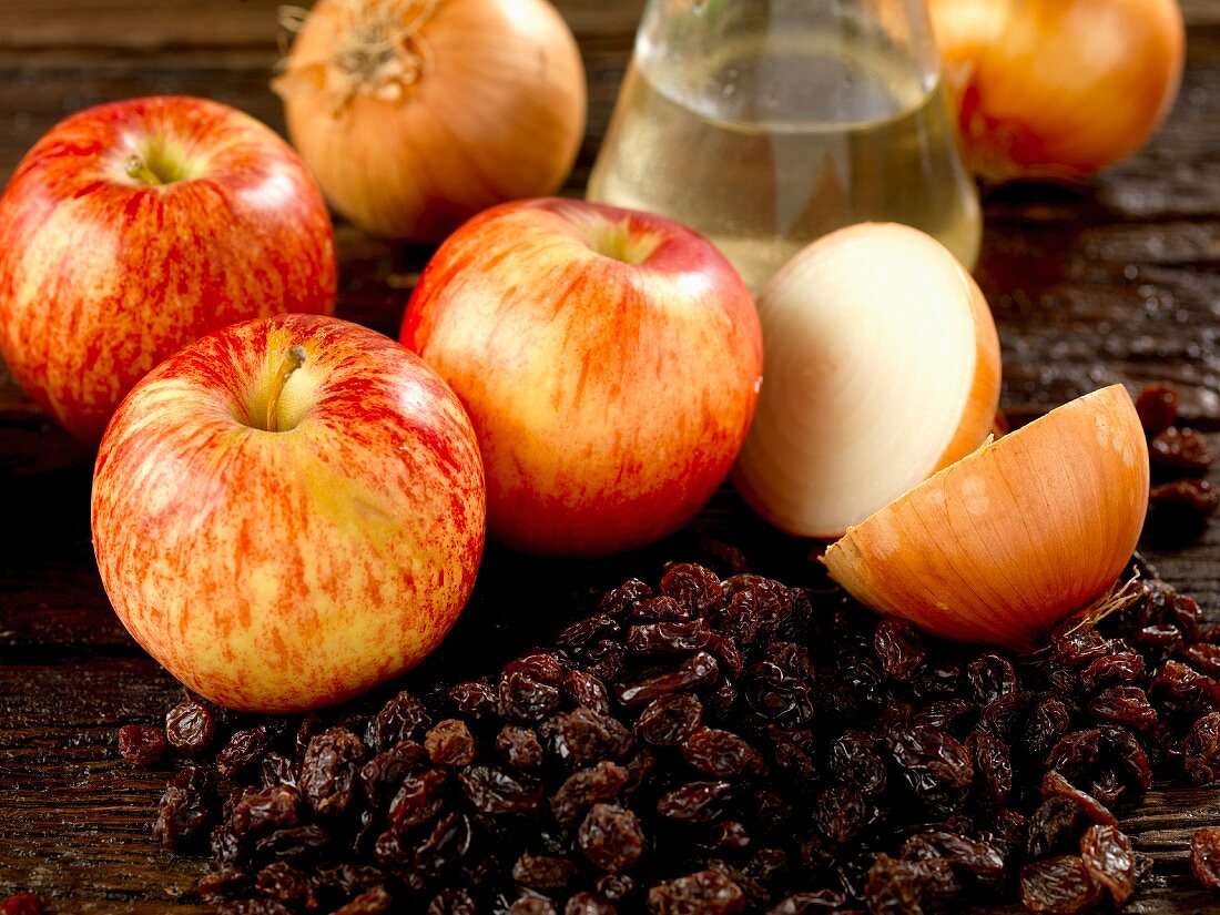 Zutaten für ein Chutney mit Apfel, Rosinen, Zwiebeln und Weissweinessig