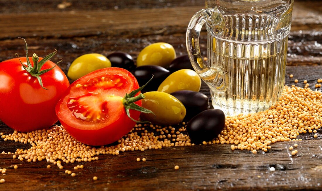 Ingredients for salad dressing with sesame seeds, tomatoes, olives and white wine vinegar