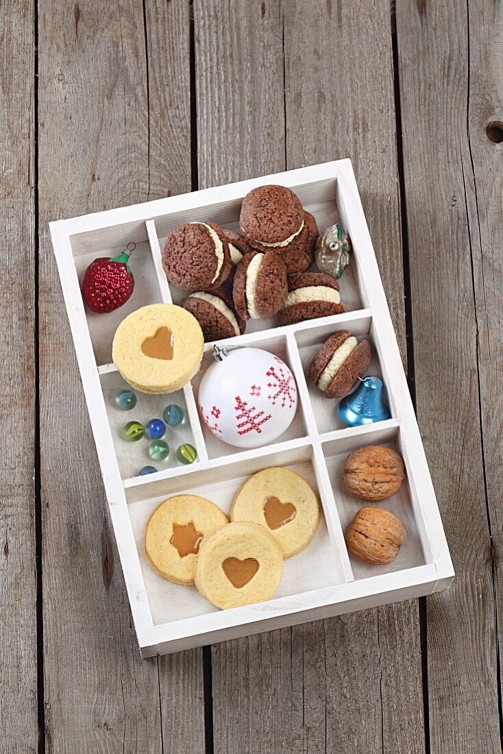 Biscuits, Christmas decorations and nuts in a seedling tray