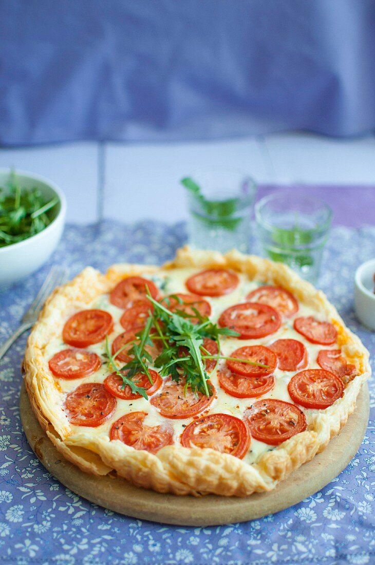 Puff pastry tart with red pestol, blue cheese, mozzarella, tomatoes and rocket