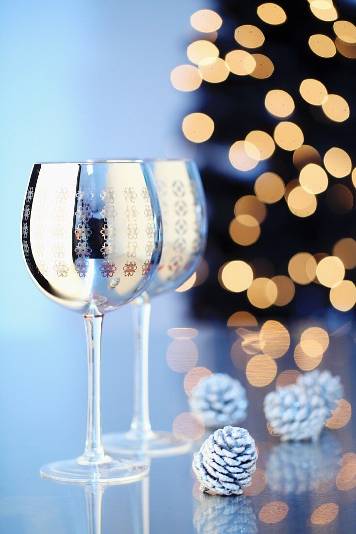 Zwei silberfarbene Weingläser mit weihnachtlichem Motivaufdruck
