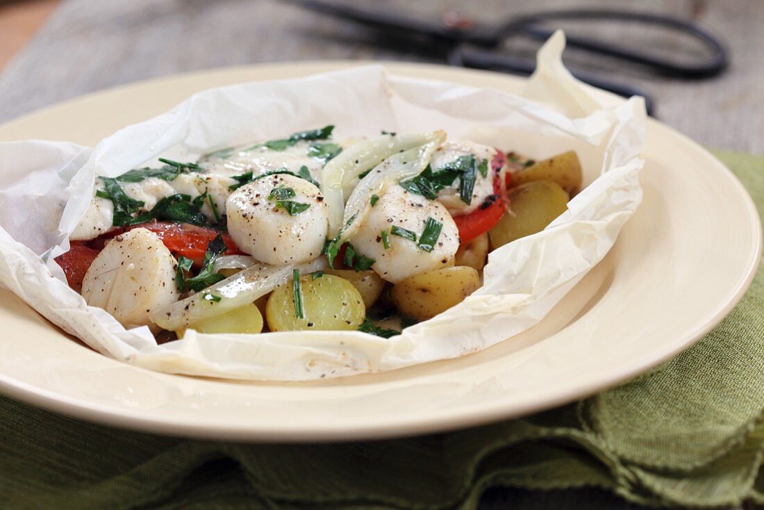 Scallops with potatoes and herbs in parchment paper