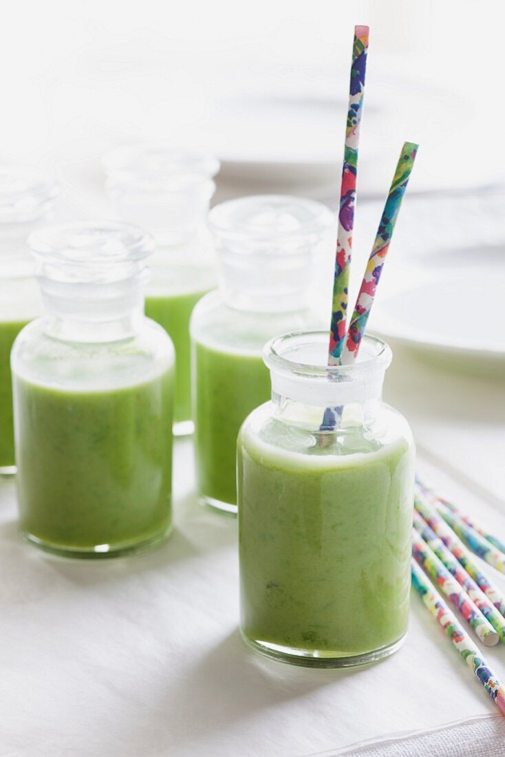 Cold pea soup in bottles with straws