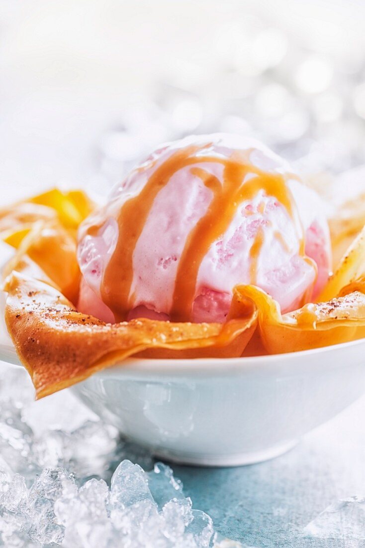 A scoop of strawberry ice cream in a puff pastry dish