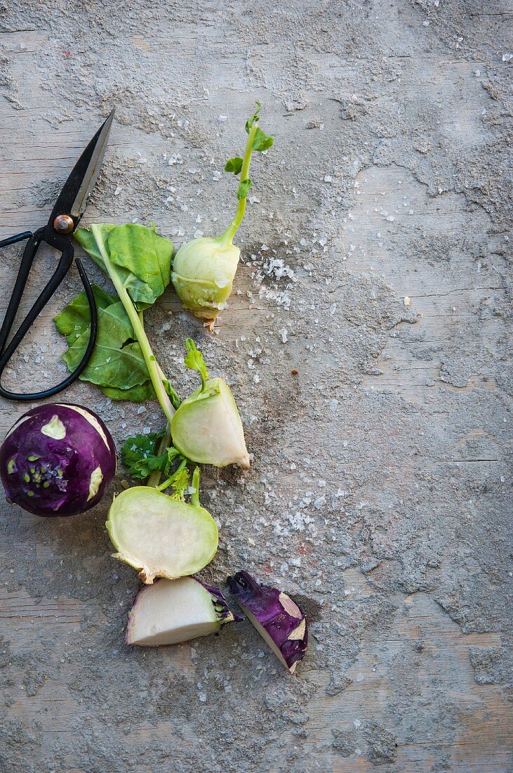 Green and purple kohlrabi on a stone surface