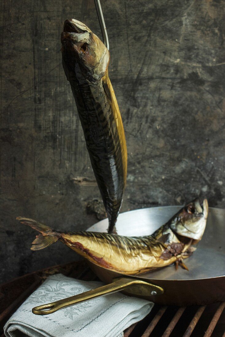 Smoked mackerel, one hanging and one in a copper pan