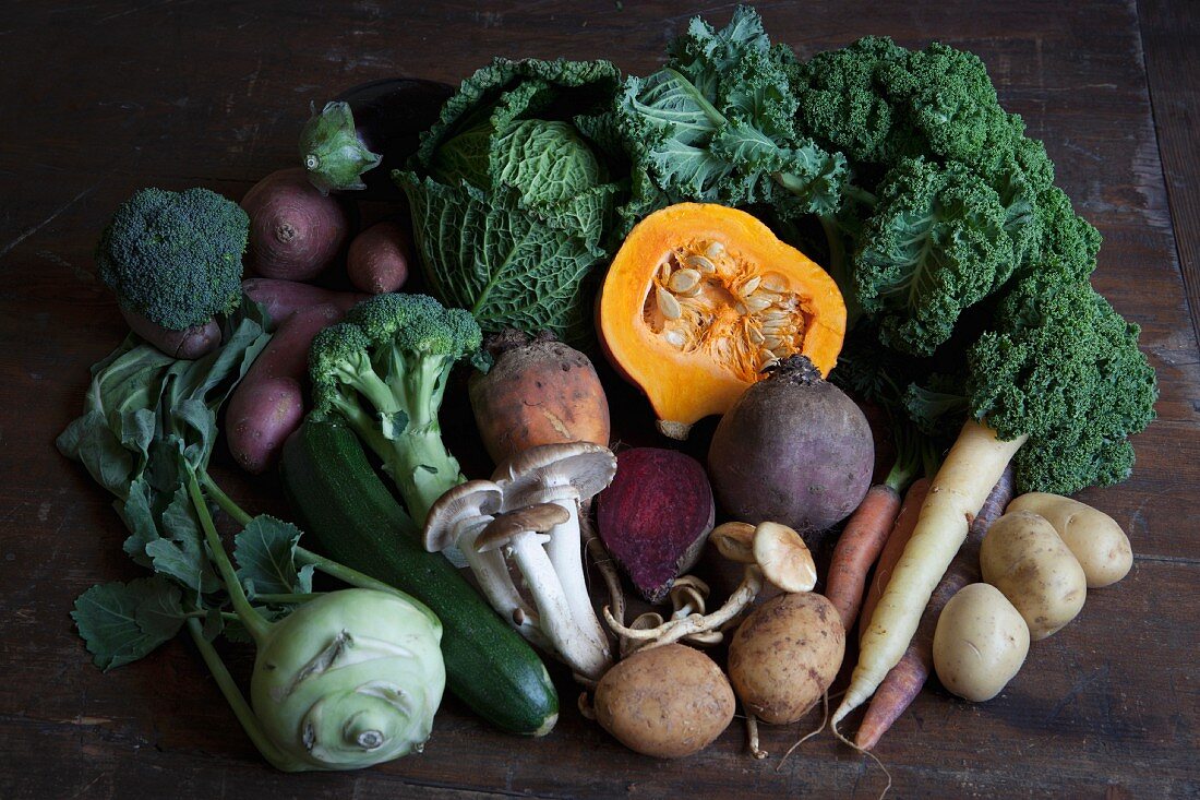 Fresh autumnal vegetables and mushrooms on a wooden table