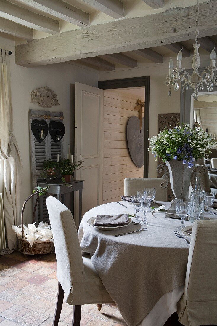 Set dining table and loose-covered chairs in rustic interior