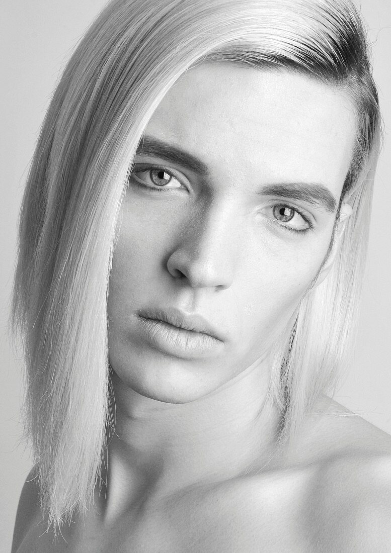 An androgynous young man with long blonde hair (black and white shot)