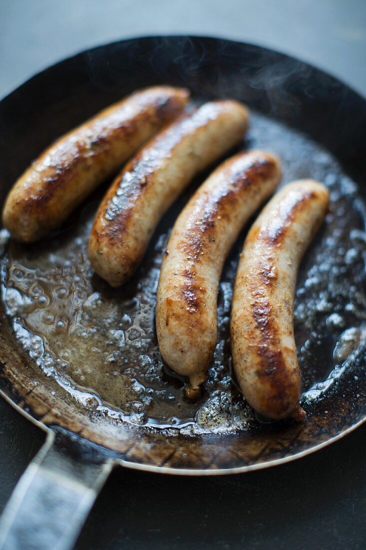 Four sausages in a pan