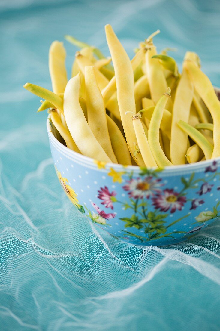 Yellow wax beans in floral patterned bowl