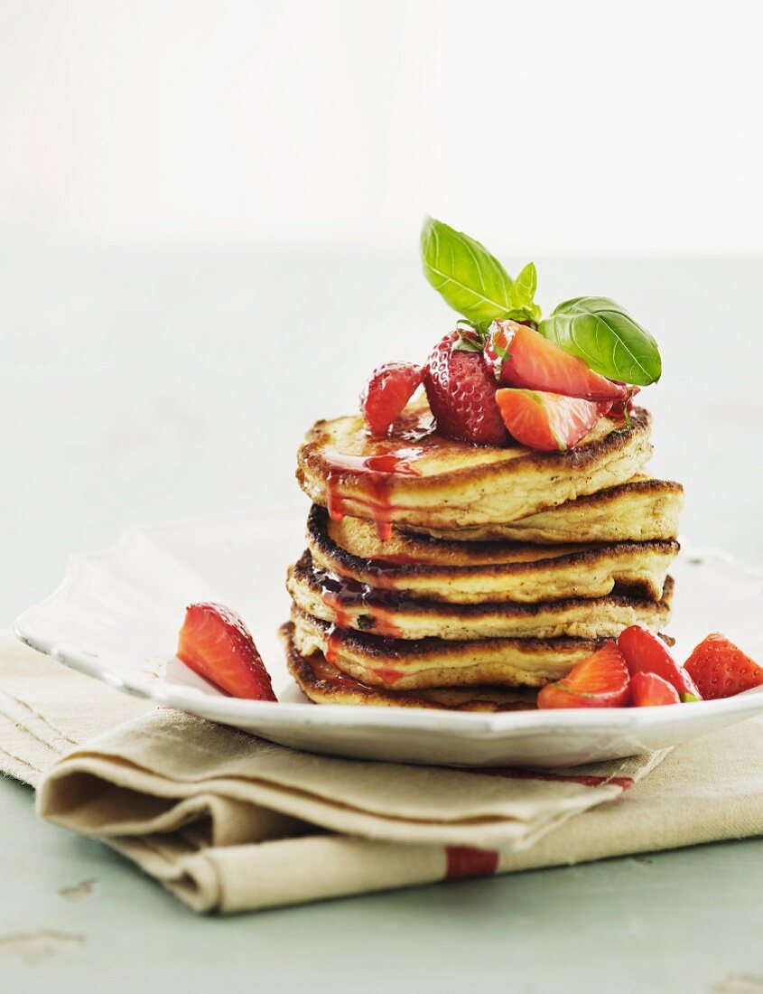 A stack of pancakes with fresh strawberries