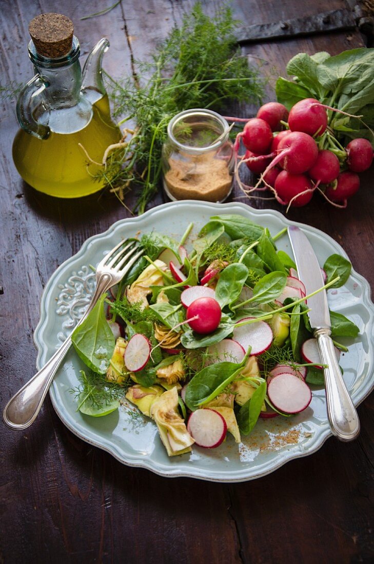 A mixed salad with baby spinach, radishes and artichokes