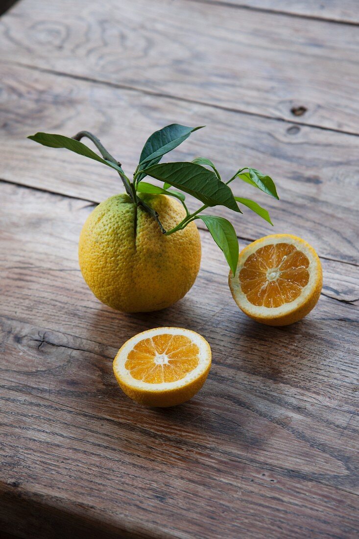Bio-Orangen, ganz und halbiert, mit Blättern