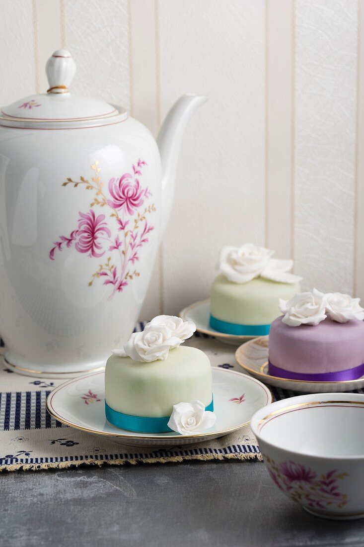 Mini cakes covered with ready roll icing and decorated with sugar roses