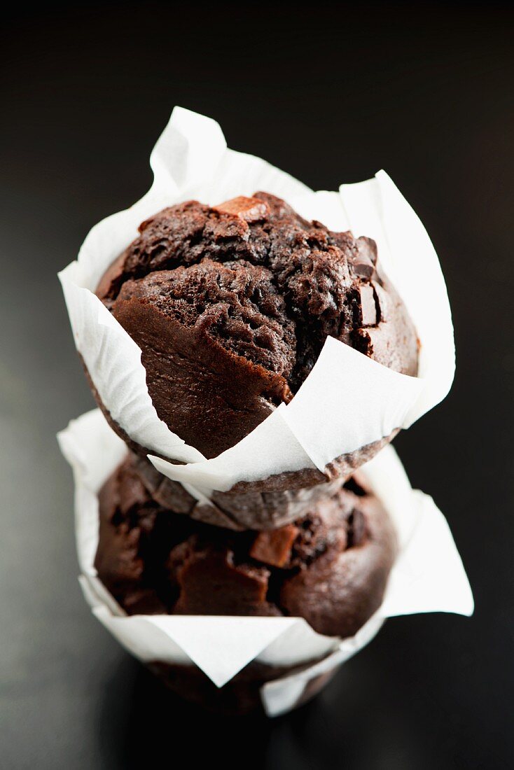 Two chocolate muffins in white paper