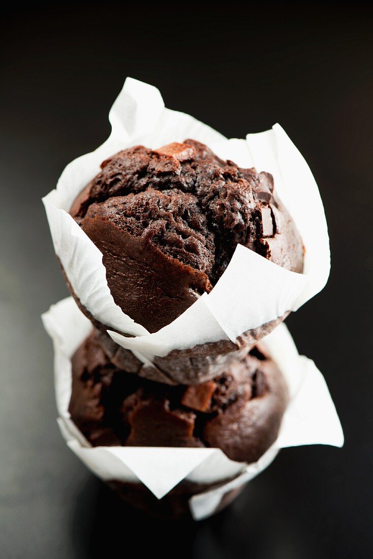 Zwei Schokoladenmuffins in weißem Papier