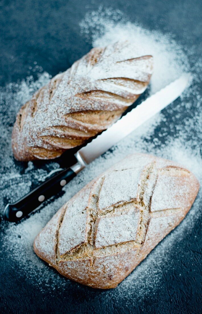Bread dusted with flour with a bread knife