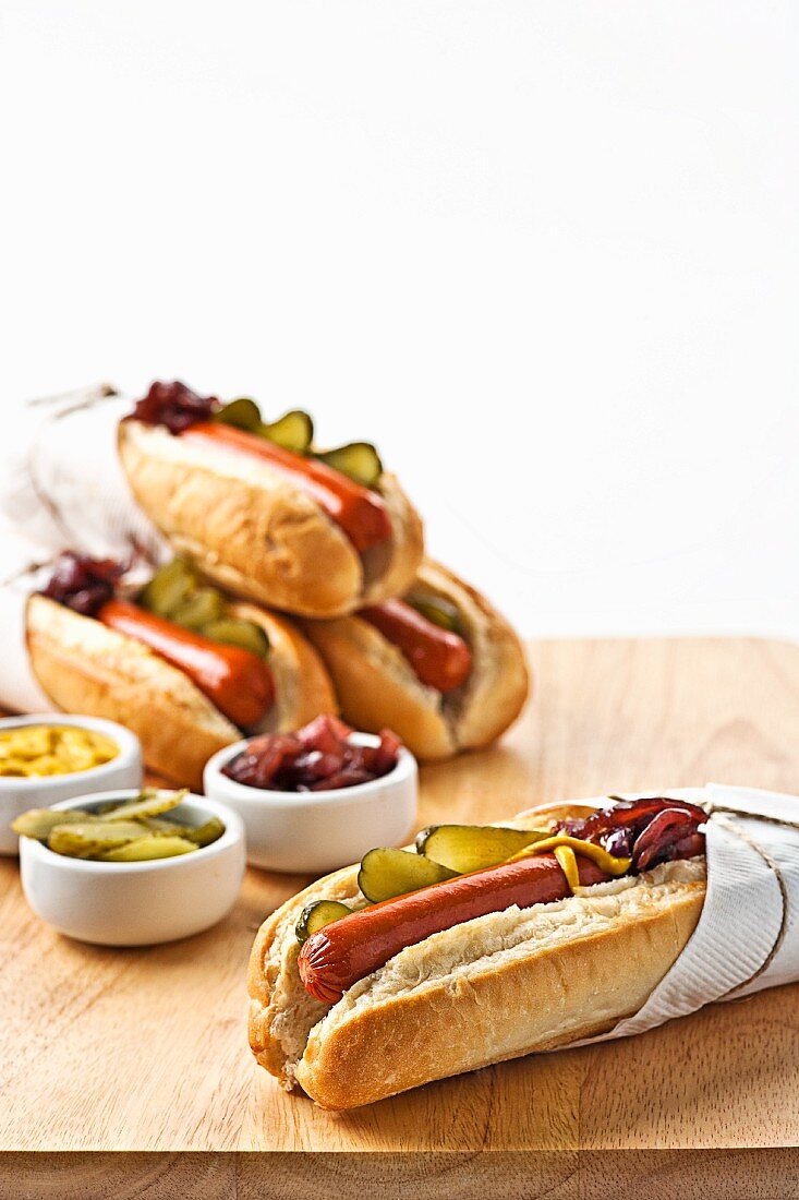 Hotdogs in Brötchen mit Essiggurken, Senf und Relish