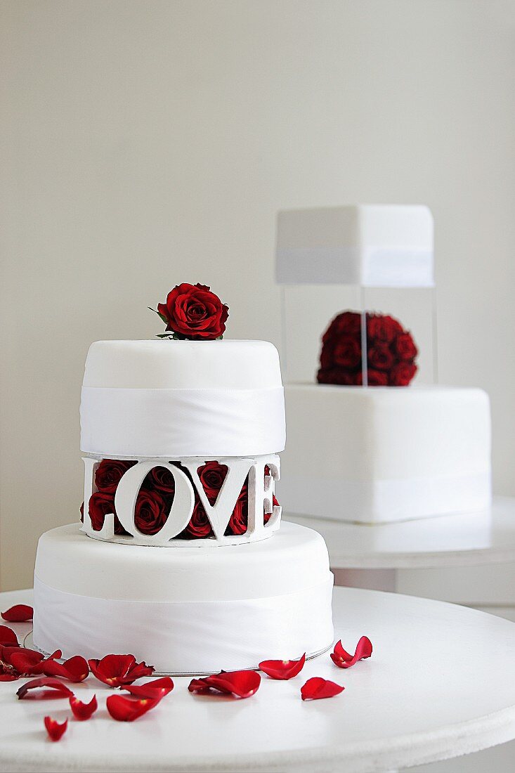 Zwei Hochzeitstorten mit roter Rosendeko