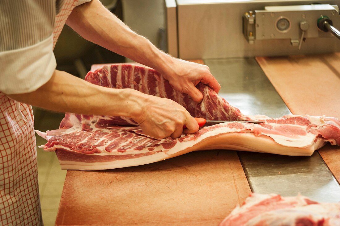 A butcher carving pork