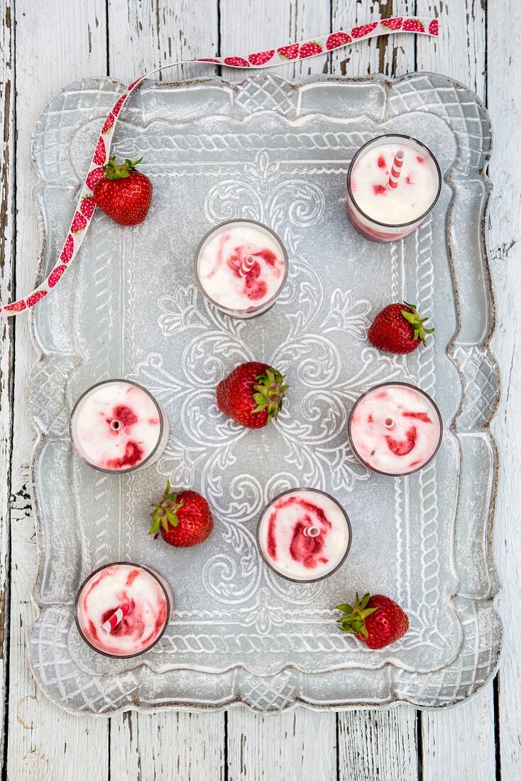 Selbstgemachtes Buttermilcheis mit Erdbeeren in Gläsern auf Tablett
