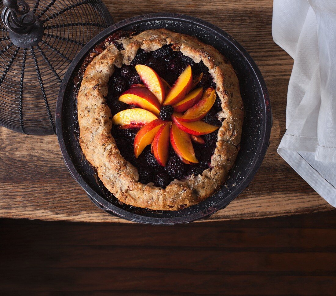 Brombeer-Pfirsich-Galette auf Holztisch