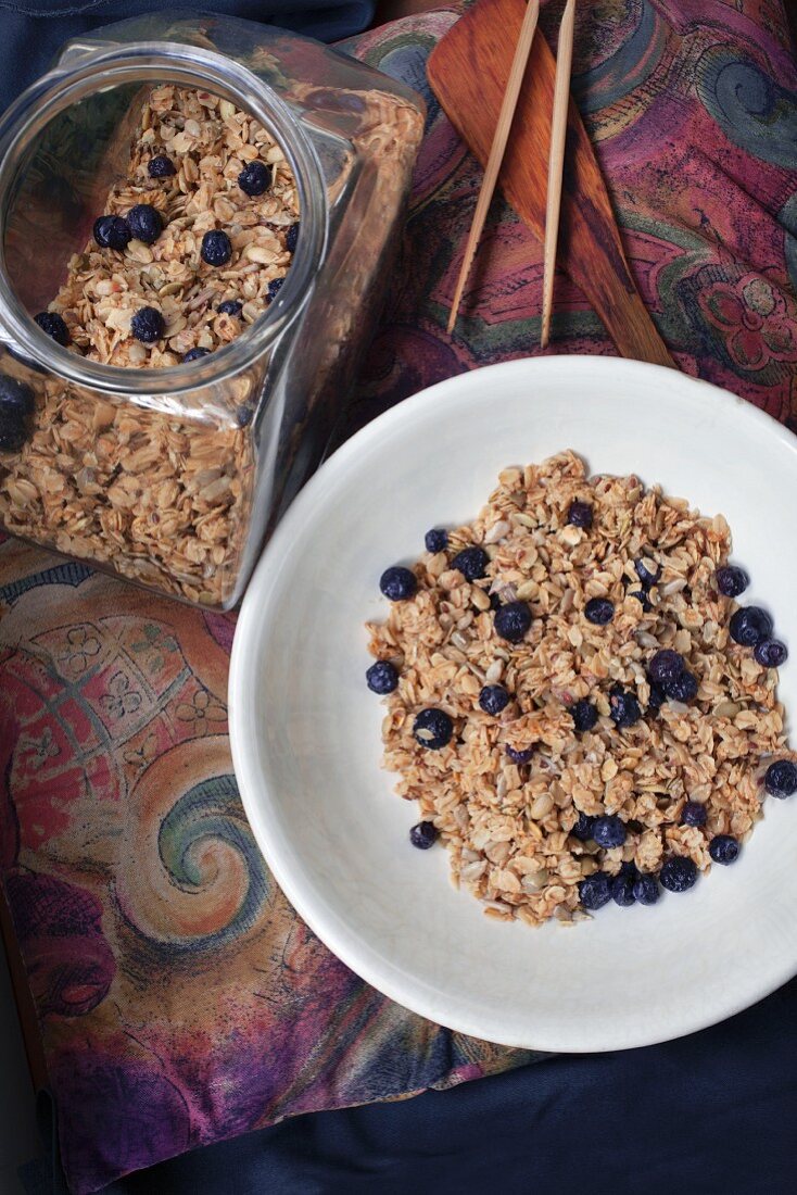 Homemade muesli with blueberries in a jar and on a plate