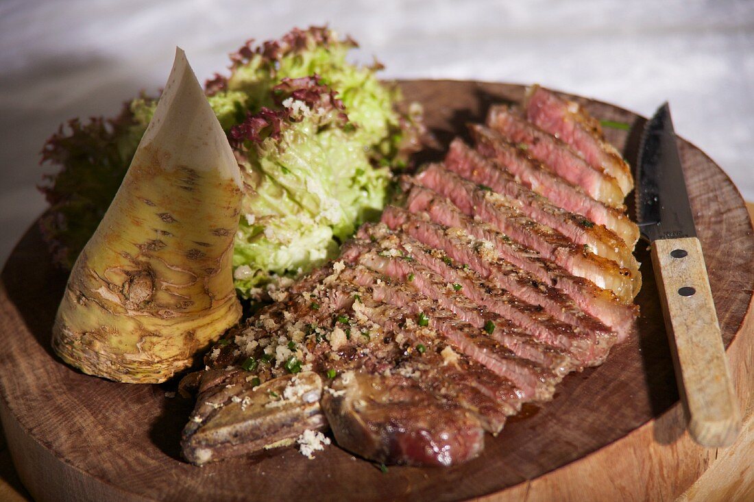 A sliced beef steak with fresh horseradish