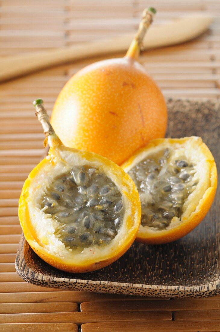 Yellow passion fruit, whole and cut in half