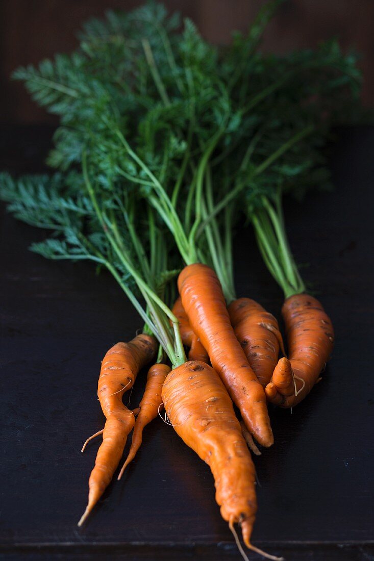 Fresh organic carrots on a dark surface