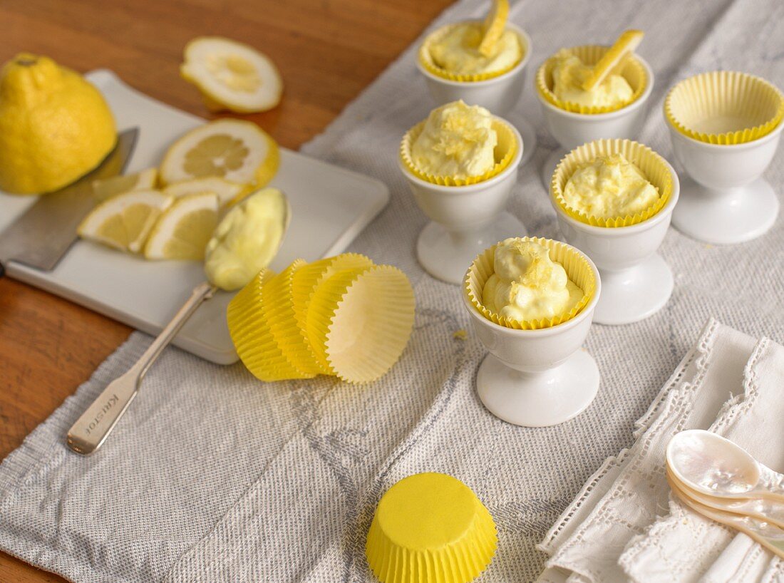Zitronencreme serviert in Papierförmchen & Eierbechern