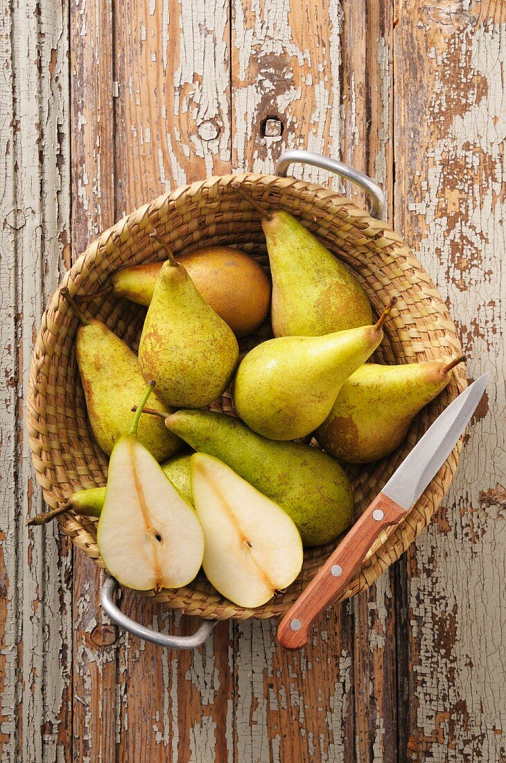 A basket of pears on a rustic wooden table
