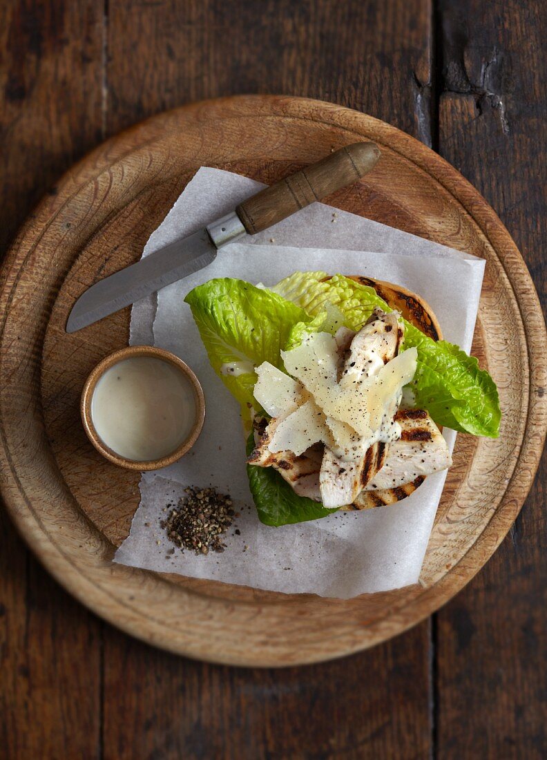 Toast topped with grilled chicken, lettuce and shaved Parmesan