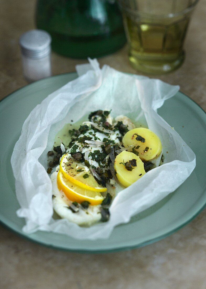 Cod with capers, parsley, lemons and potatoes in parchment paper