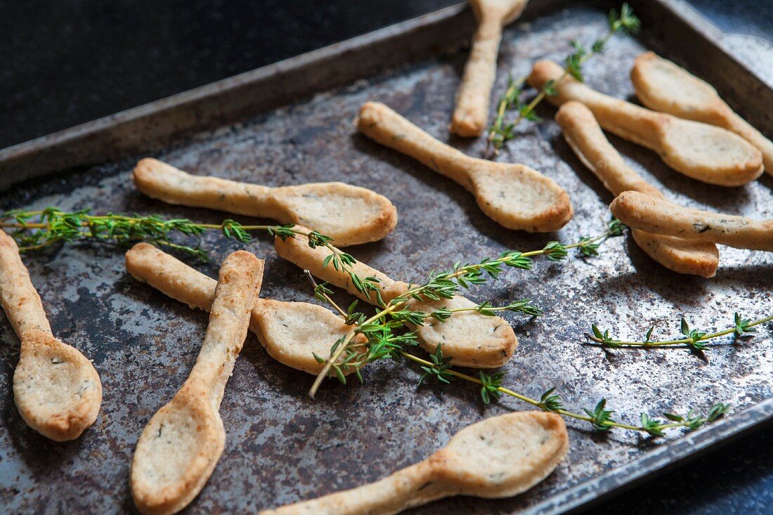 Savoury spoon shaped biscuits with thyme and Parmesan on a baking tray