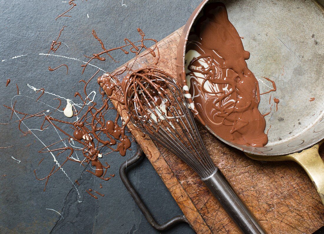 Melted milk chocolate with a whisk and a saucepan