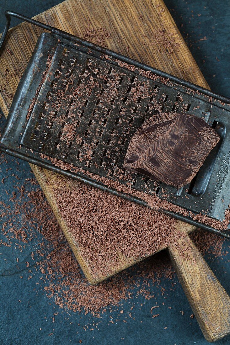 Geriebene Zartbitterschokolade mit Reibe und Schokoladenstück