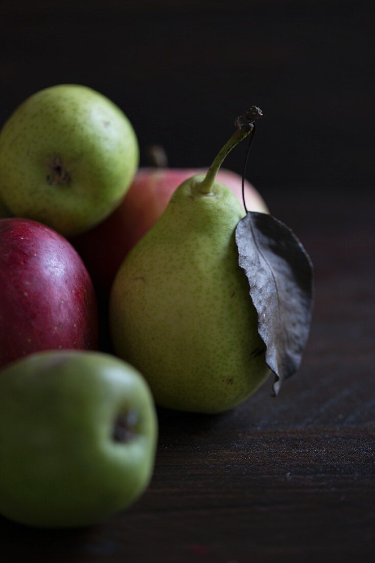 Pears and apples on a dark wooden surface