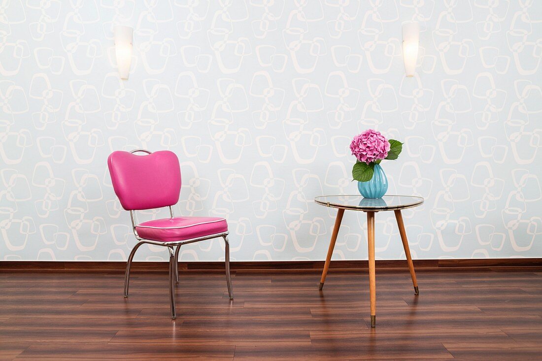 Hairdresser's waiting area with pink chair & triangular, 50s table