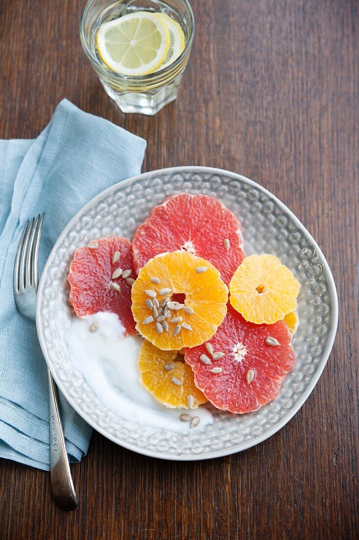 Zitrussalat mit rosa Grapefruit, Orangen, Sonnenblumenkernen und Joghurt